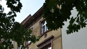 Un edificio de varios pisos con un estilo arquitectónico clásico, que presenta una serie de ventanas y molduras decorativas.
