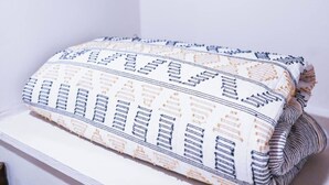 A neatly organized closet with hanging clothes and folded blankets. - Private Basement Studio - Near Wash Park (Denver)
