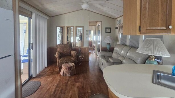 A compact living space with a kitchenette, a sofa, a chair, and a dining table. - Woody's RV Resort (Sebring)