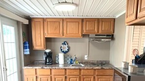 A kitchen with wooden cabinets, a microwave, and a coffee maker. - Woody's RV Resort (Sebring)