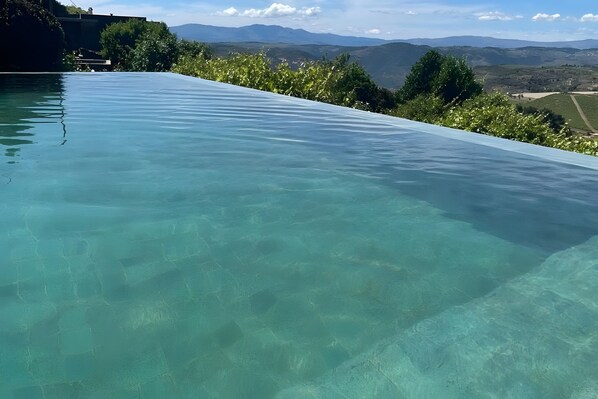 A clear infinity pool with a view of distant mountains.