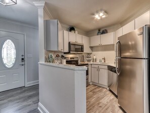 A modern kitchen with white cabinetry, stainless steel appliances, and a central island. - Tranquility Skies | MTN View, Sauna, Jacuzzi, MORE (Gatlinburg)