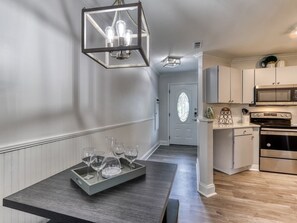 A modern kitchen with a central island, stainless steel appliances, and a hanging light fixture. - Tranquility Skies | MTN View, Sauna, Jacuzzi, MORE (Gatlinburg)