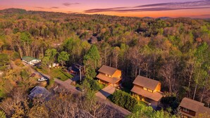 Vue aérienne d’un quartier résidentiel composé de nombreuses maisons, entouré d’une forêt dense.