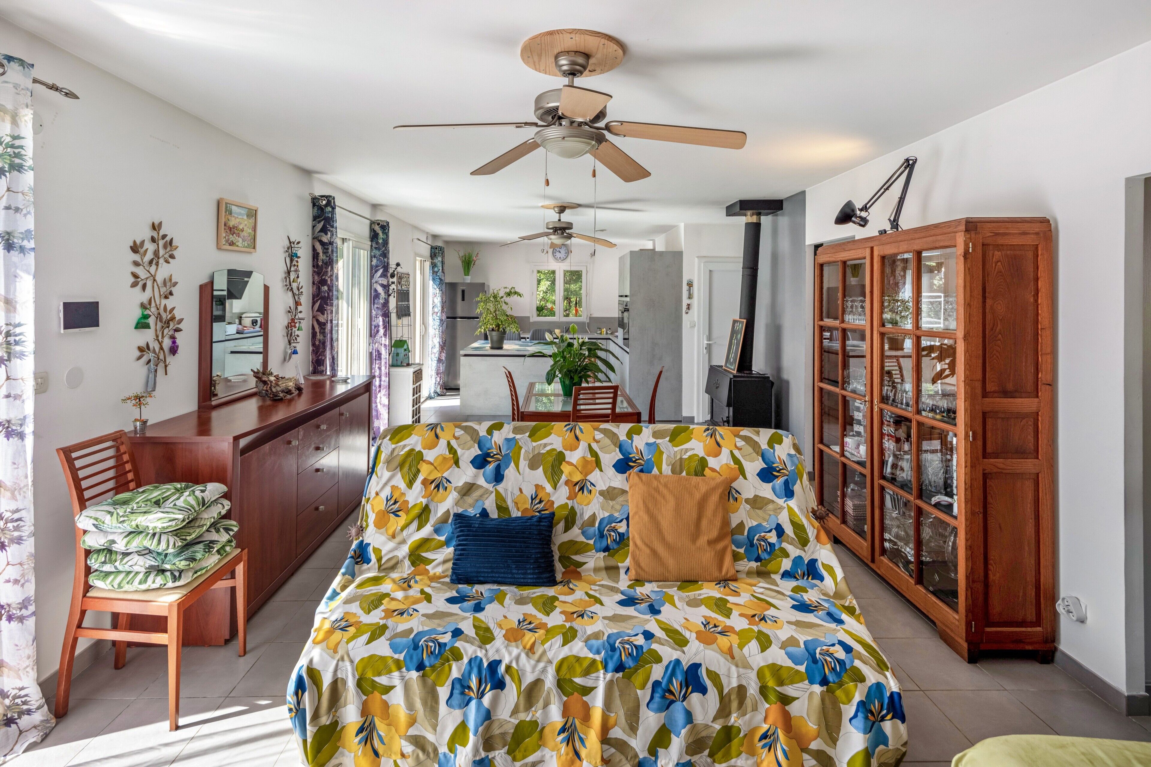 A room with a bed, a desk, a chair, a cabinet, and a ceiling fan.