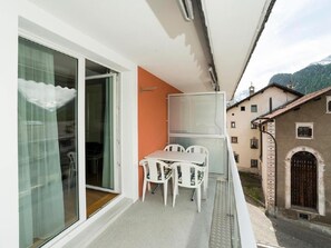A balcony with a table and chairs, a sliding glass door, and a view of a mountain. - Chesa Quadrella by Interhome (Pontresina)