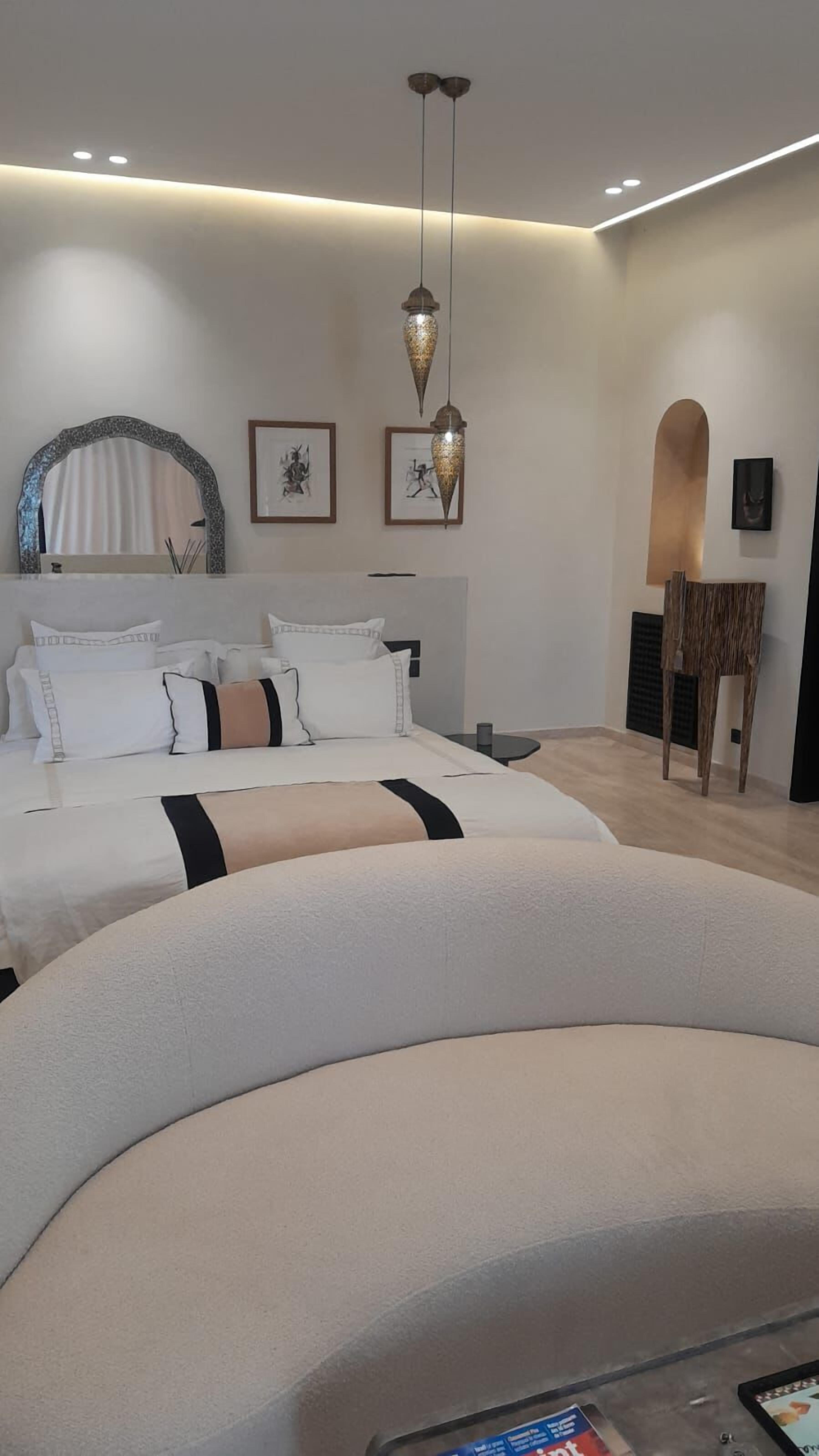 A modern bedroom with a large bed, a desk, and a chair.