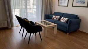 A living room with a sofa, a coffee table, and a chair. - Chesa Quadrella by Interhome (Pontresina)