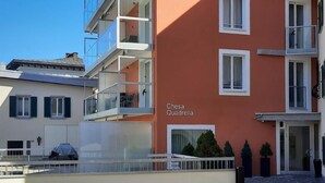 A building with balconies, a sign reading 'Chesa Quadrella,' and a paved courtyard. - Chesa Quadrella by Interhome (Pontresina)