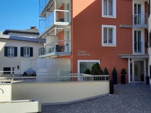 Ein Gebäude mit Balkonen, einem Schild mit der Aufschrift 'Chesa Quadrella' und einem gepflasterten Innenhof.