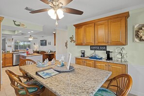 A kitchen with wooden cabinets, a granite countertop, and a ceiling fan. - A one of a kind oasis, 7 miles from beautiful Annamarie Island IMG academy (Bradenton)