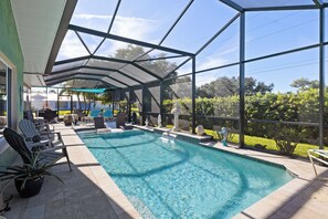 A covered outdoor swimming pool with lounge chairs and a patio area. - A one of a kind oasis, 7 miles from beautiful Annamarie Island IMG academy (Bradenton)