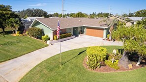 A residential house with a front yard, a driveway, and a flag. - A one of a kind oasis, 7 miles from beautiful Annamarie Island IMG academy (Bradenton)