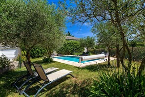 A swimming pool with lounge chairs, surrounded by trees and greenery. - Apartment "Gîte La Freydière" Surrounded by Nature in Drôme Provençale (La Bégude-de-Mazenc)