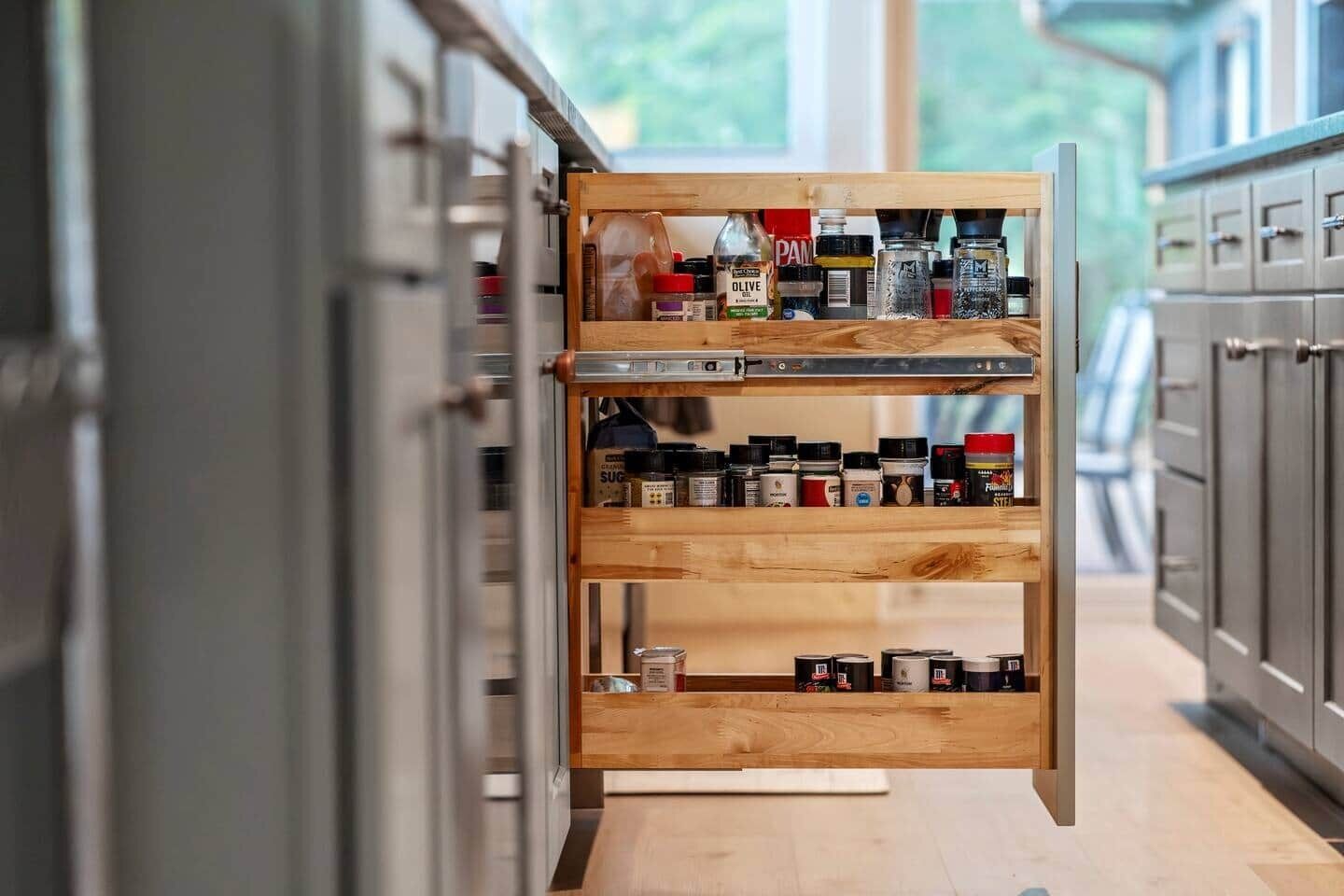 A kitchen with a wooden spice rack and cabinets.