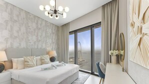A modern hotel room with a large bed, a view of a bridge, and a cityscape. - Exceptional high floor 3bed apartment by Suiteable (Dubai)