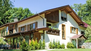 Ein zweistöckiges Haus mit Balkon, großen Fenstern und einem Steinkamin.