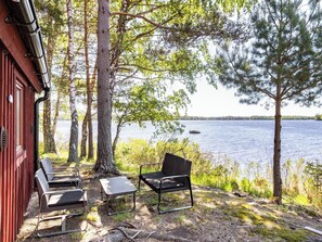 A cabin with outdoor seating, a view of a lake, and surrounding trees. - Vacation home Rönnö by Interhome (Tingsryd)