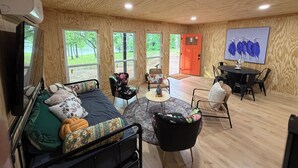 Un intérieur en bois comprenant un lit, une table à manger, des chaises et un téléviseur.