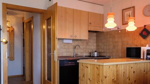 Una cocina con armarios de madera, un fregadero, una estufa y un microondas.