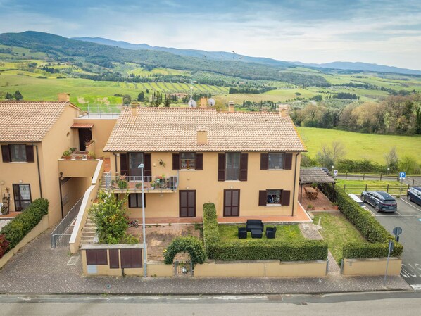 A two-story building with a tiled roof, a balcony, and a small garden area. - I Quadri by Interhome (Casale Marittimo)