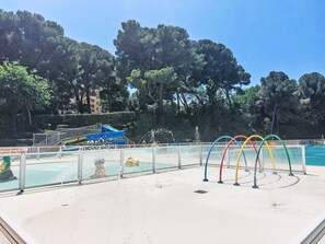 Ein Swimmingpool mit Wasserrutsche und bunten Wasserstrahlen.