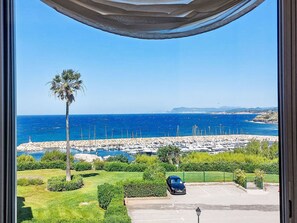 A coastal view with a marina, parked car, and greenery. - Le Grand Large by Interhome (Six Fours La Coudoulière)