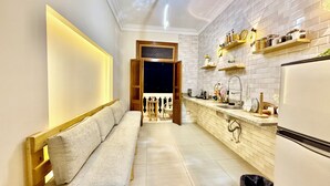 Una cocina moderna con horno empotrado, un lavamanos y una encimera con diversos utensilios de cocina.