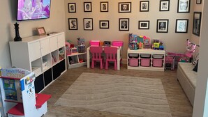 A children's playroom with a television, framed pictures, and a play area. - World Cup Ready Spacious 5BR Home Near Atlanta Stadium & Downtown Restaurants (Fairburn)