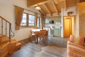 A wooden interior with a dining area, kitchen, and a sofa. - Apartment 'Rododendro' with Mountain View, Shared Garden and Wi-Fi (Livigno)