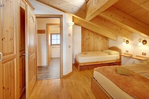 Une pièce en bois avec un lit, une table de chevet et une armoire.