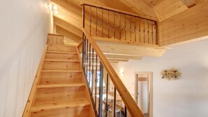 Un escalier en bois avec une rampe métallique menant à un niveau supérieur.