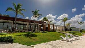 A modern hotel with a well-maintained lawn, palm trees, and sun loungers. - Pool View, Gym, and Artificial Beach (Punta Cana)
