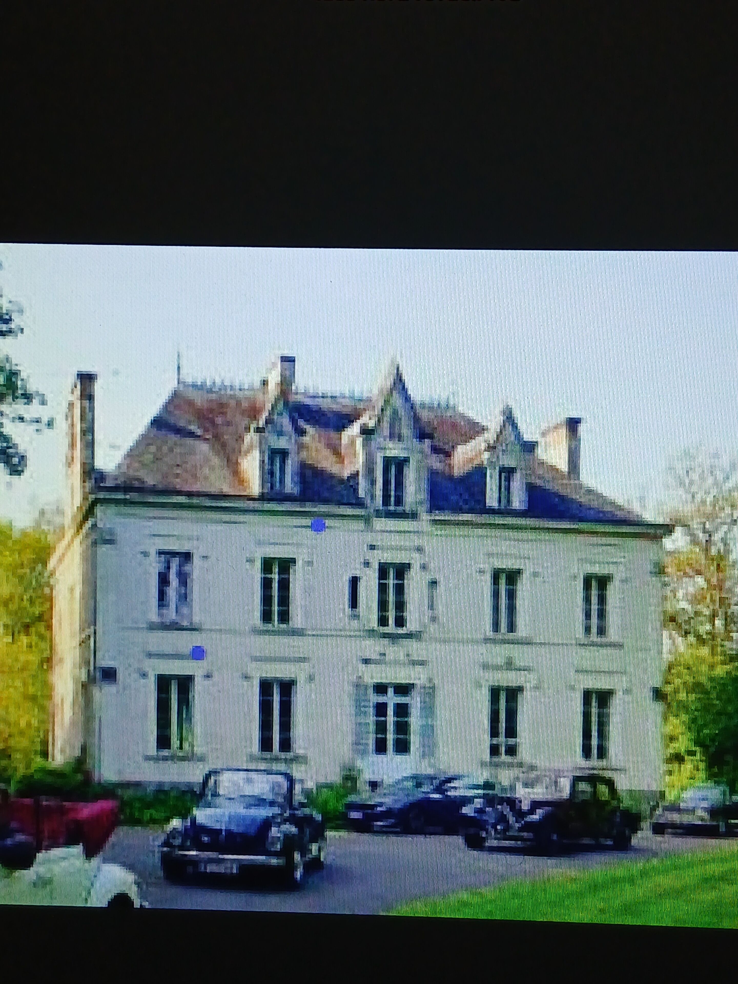 Ein großes, mehrstöckiges Gebäude mit einer symmetrischen Fassade, zahlreichen Fenstern und einem zentralen Eingang.