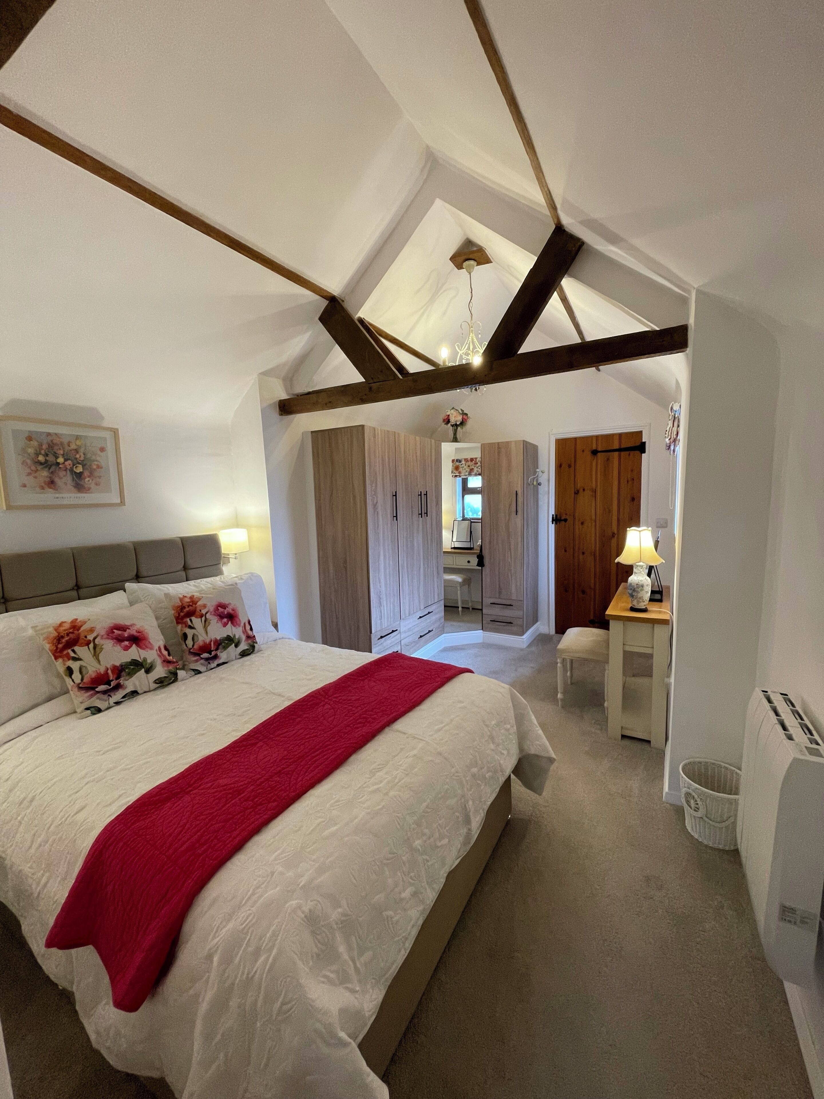 Un dormitorio con cama, escritorio y silla.