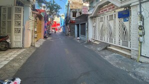Una stretta via fiancheggiata da edifici, alcuni con insegne che indicano attività commerciali.