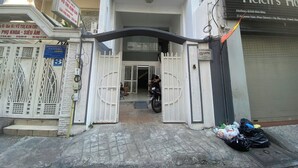 Una entrada con portón a un edificio, con una motocicleta estacionada en su interior.