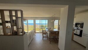 A modern kitchen with a dining area and large windows. - VAL D'AZUR Panoramic Sea View - Air-conditioned 4-room apartment - Center and Beach (Bandol)