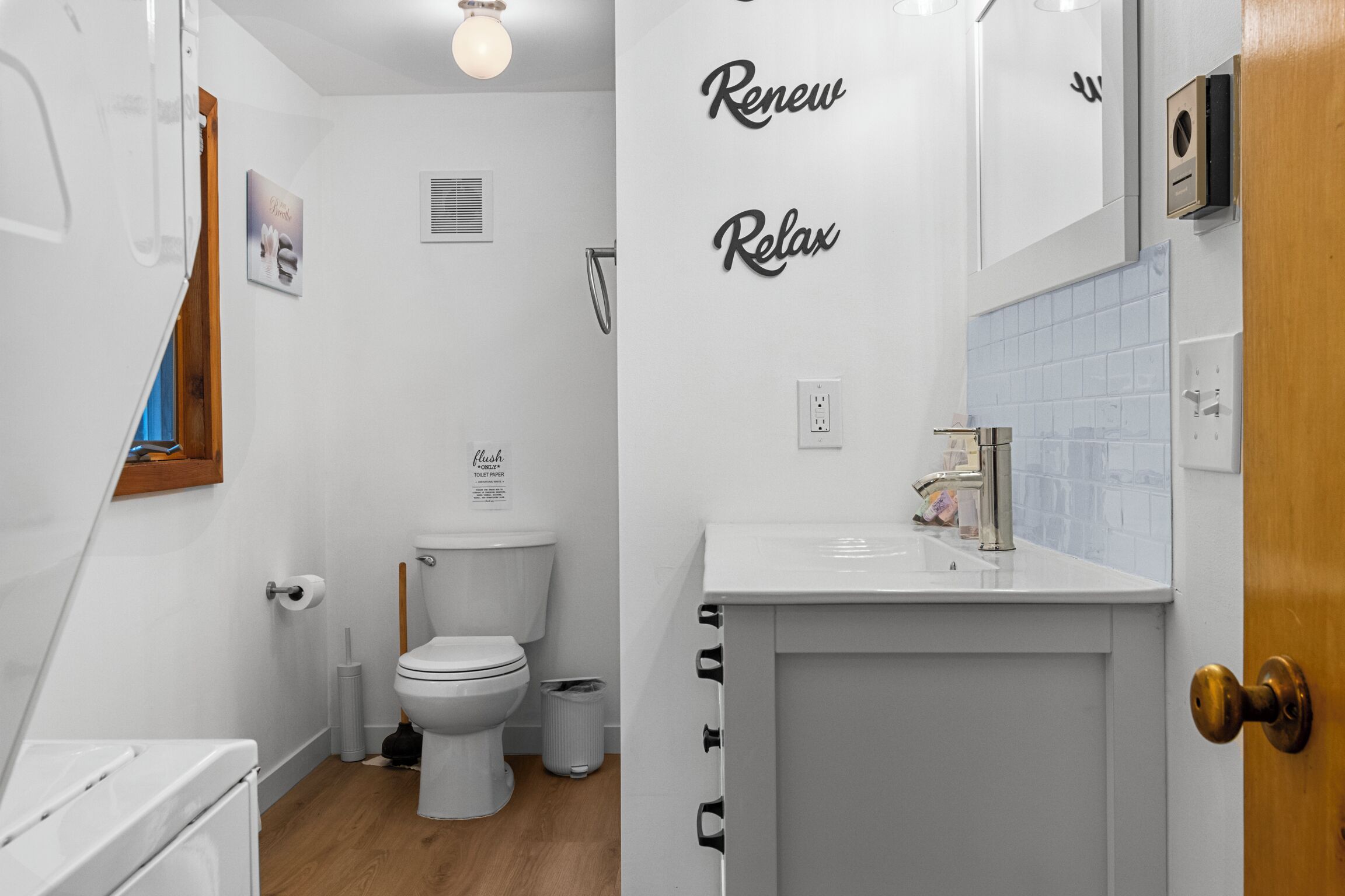 Een badkamer met toilet, wastafel en een spiegel aan de muur.