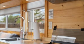 A kitchen with a sink, faucet, and a cylindrical object on the counter. - Tiny Home, Big Comfort - E Austin Escape w W/D Mins to DT & Lady Bird Lake (Austin)