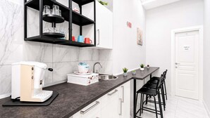 Una cucina moderna con macchina da caffè, lavello e zona bar con sedie.