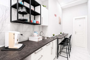 Eine moderne Küche mit Kaffeemaschine, Spüle und einer Bar mit Stühlen.
