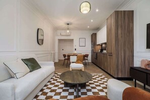 A modern living room with a sofa, a round coffee table, and a checkered rug. - Terrific apartment 2BDR/6PAX next the Eiffel Tower (Paris)