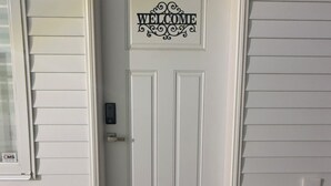A white door with a 'WELCOME' sign above it and a doormat below. - Cozy and new self contained apartment in our home in Mission, British Columbia (Mission)