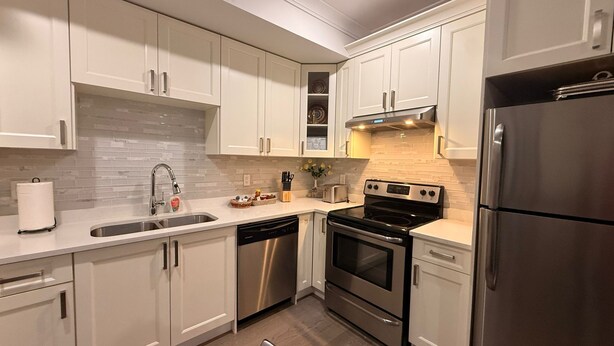 A modern kitchen with white cabinets, stainless steel appliances, a dishwasher, and a tiled backsplash. - Cozy and new self contained apartment in our home in Mission, British Columbia (Mission)