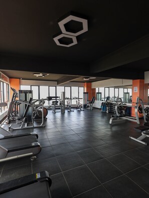 A gym with various exercise equipment, large windows, and a modern design. - Stylish 2BR&SQ in Westlands | gym, pool, cafe (Nairobi)