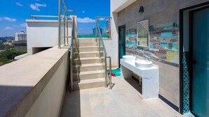 Ein modernes Gebäude mit einer Treppe, die zu einem Balkon führt, einer Wand mit farbenfrohem Musterfliesen und einem Badezimmer mit zwei Waschbecken.