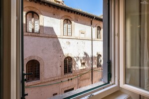 Ein Fenster mit Blick auf ein Gebäude, das Bogenfenster und einen Balkon zeigt.