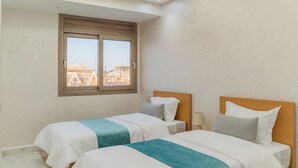 Ein Hotelzimmer mit zwei Betten, einem Fenster mit Blick und einem Oberlicht.