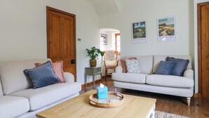 A living room with two sofas, a coffee table, a plant, and framed pictures on the wall. - Lumford Mill Cottage (Bakewell)